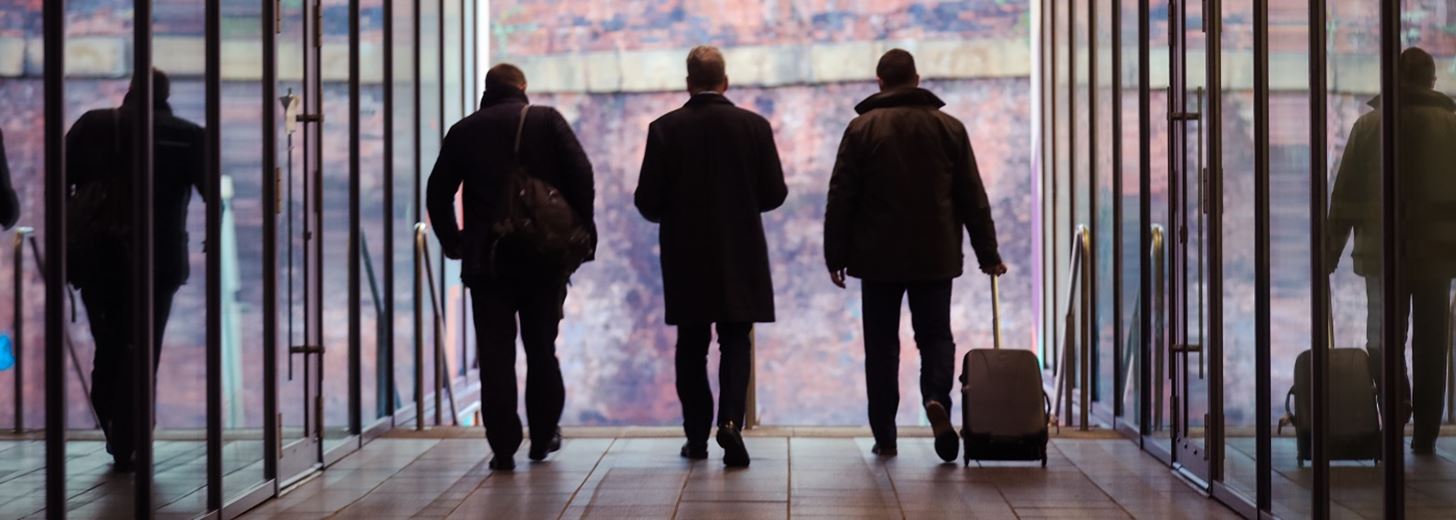 three men walking down an office corridor - relating to the decisions around northern powerhouse.